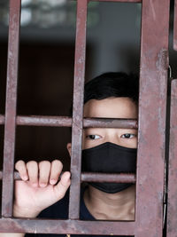 Portrait of a boy with face mask stuck indoors