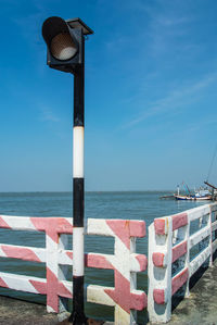 Lifeguard hut on beach against blue sky