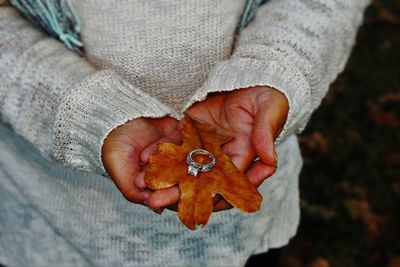 Midsection of woman holding ring during autumn