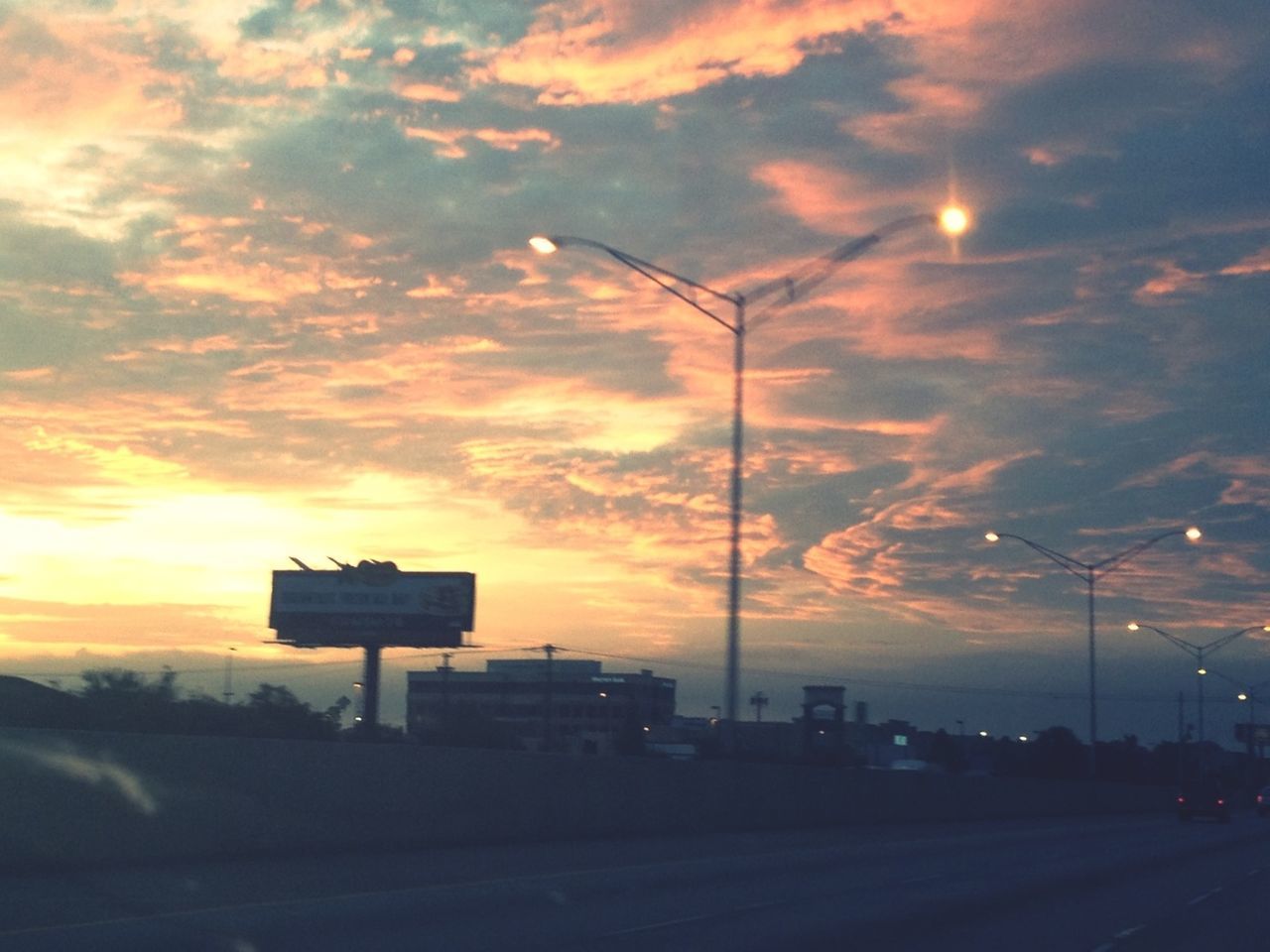 sunset, sky, cloud - sky, silhouette, street light, cloudy, road, orange color, dramatic sky, scenics, weather, beauty in nature, nature, transportation, fuel and power generation, tranquility, cloud, street, electricity pylon, dusk