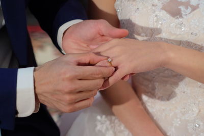 Midsection of couple holding hands