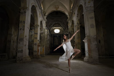 Full length of ballet dancer dancing in historic building