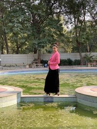 Portrait of woman in swimming pool against trees