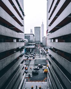 Traffic on road in city seen through buildings