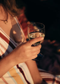 Midsection of woman holding glass of champagne 
