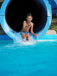 Full length of smiling boy in swimming pool