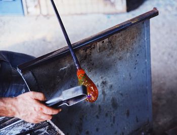 Midsection of man working on glass in workshop