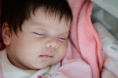 Close-up of baby sleeping on bed