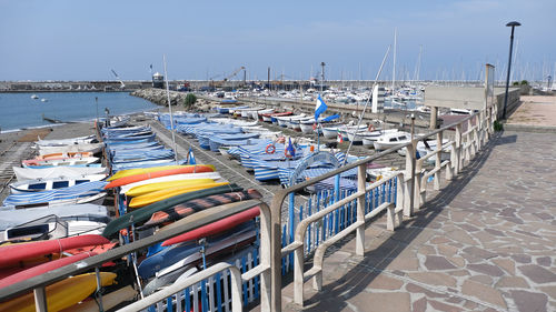 Boats moored at harbor against clear sky