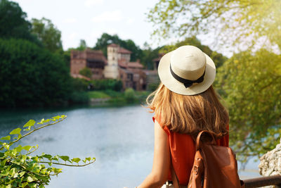 Traveler girl with backpack discovering hidden castle in the park.