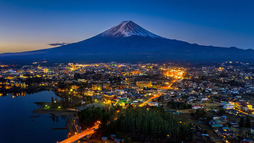 Aerial view of illuminated city against sky