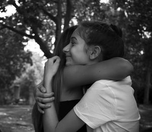 Full length of woman sitting against trees