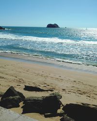 Scenic view of beach against blue sky