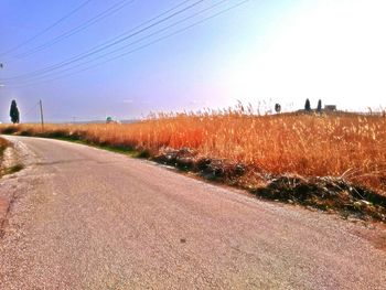 Road amidst field against sky