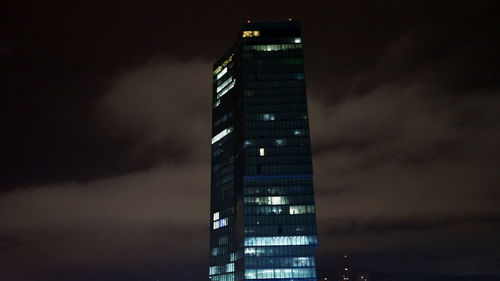 Low angle view of illuminated buildings against sky at night