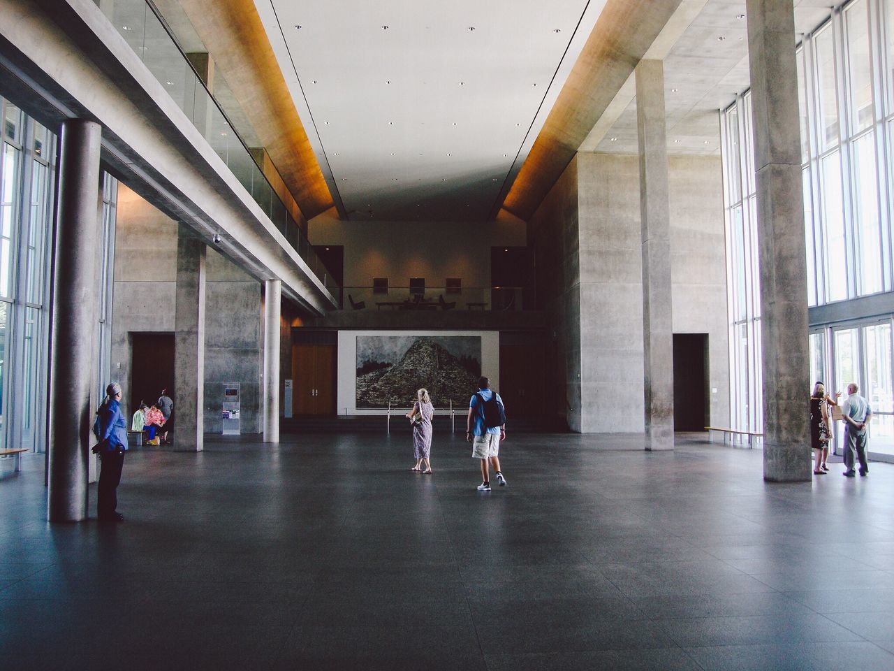 indoors, lifestyles, men, ceiling, architecture, built structure, person, leisure activity, flooring, corridor, full length, walking, illuminated, casual clothing, rear view, architectural column, standing, large group of people, reflection