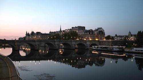 Bridge over river in city against clear sky