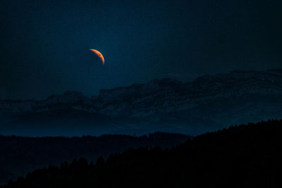 Scenic view of silhouette mountains against sky at night