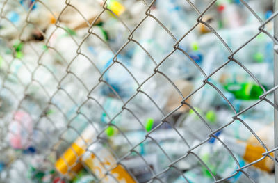 Blurred photo of pile of empty water plastic bottle in mesh fence recycle bin. plastic bottle waste.