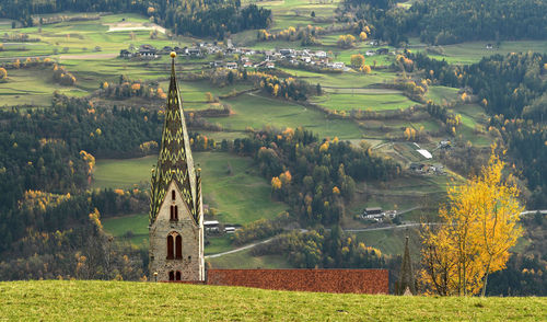 Scenic view of agricultural field against trees and buildings