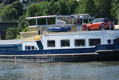 Boats moored in river against trees