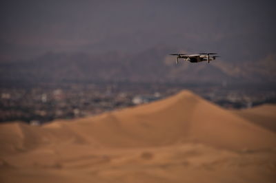 Drone flying above sand dunes of huacachina desert in peru
