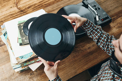 Man listening to music from vinyl record. playing music from analog disk on turntable player. hobby