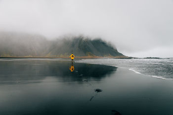 Rear view of man running on shore at beach