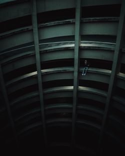 Man sitting on railing of building