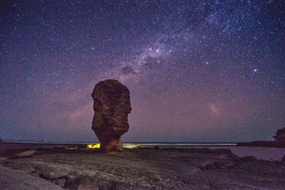 Full length of rock formations against sky at night