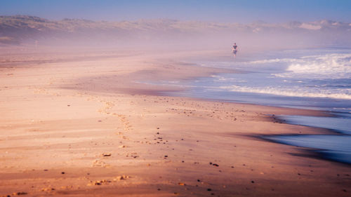 Scenic view of beach against sky during sunset