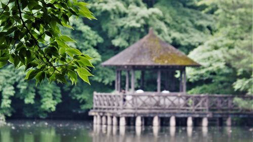 Built structure by lake against trees