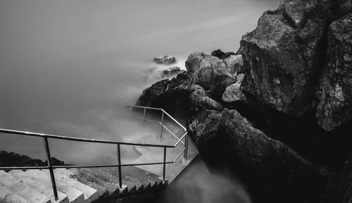 High angle view of steps leading towards rocky seashore