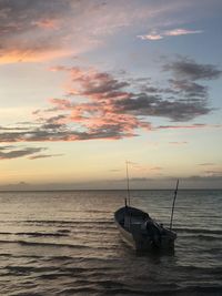 Sailboat in sea against sky during sunset