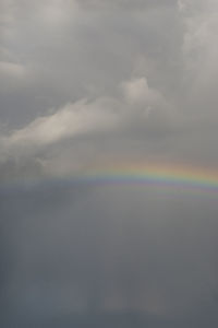 Low angle view of rainbow against cloudy sky