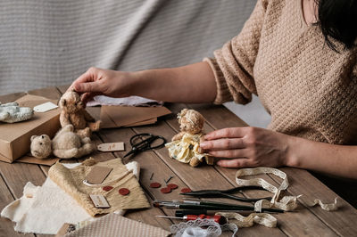 A young woman sews a teddy bear. hobby