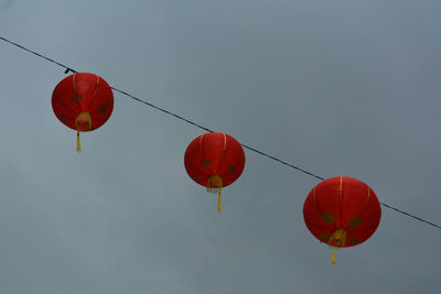 Low angle view of red lanterns hanging against sky