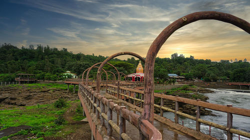 Built structure on landscape against sky during sunset