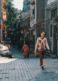 Full length of woman walking on street in city