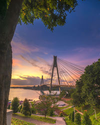 View of suspension bridge against cloudy sky