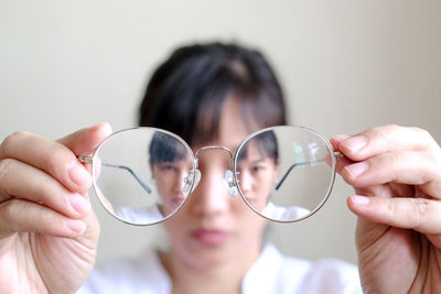 Close-up portrait of woman holding glass with reflection