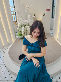 Young woman sitting on sofa at home