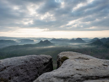 Kleiner winterberg rocky view before sunrise. crack cliff above deep valley in saxon switzerland