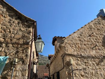 Low angle view of old building against clear blue sky