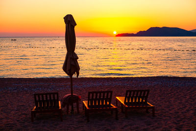 Chaise lounges and umbrella on the beach in the twilight . fantastic coastal summer vacation 