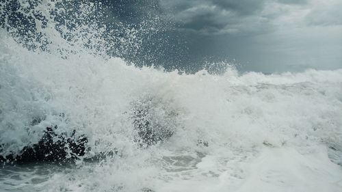 Full frame shot of sea waves splashing against sky