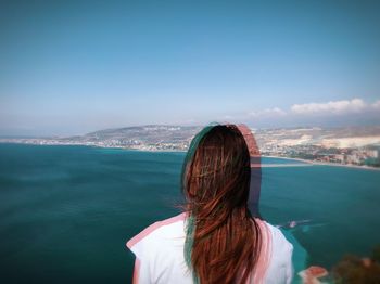 Rear view of woman looking at sea against sky