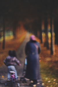 Rear view of woman walking on road