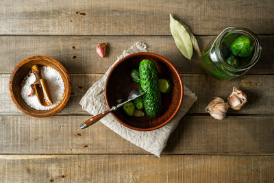 Salted cucumbers, condiments on wooden rustic background, top view
