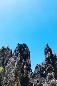 Low angle view of rocks against blue sky
